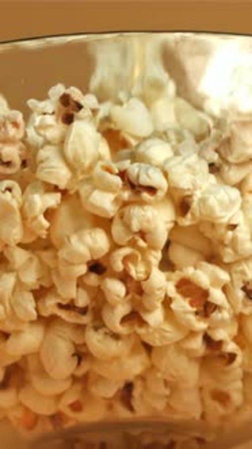 Un tazón de palomitas cae sobre un fondo amarillo filmado con una cámara de alta velocidad a 1000 fps