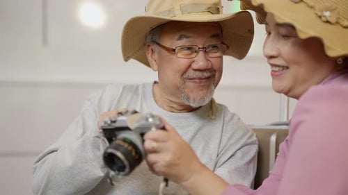 Smiling Older Couple Looking At Vintage Camera