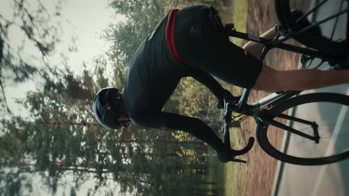 Cyclist riding road bicycle during intense cycling training. Vertical video