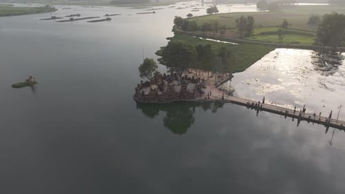 Aerial View Of A Lake With A Temple And A Long Bridge