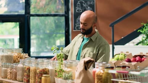 Shopkeeper Standing at Counter with Glass Jars