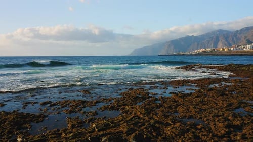 Ocean Waves Crashing on the Rocky Shore of the Beach