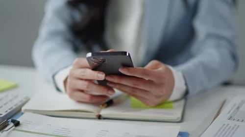 Woman Using Phone at Desk in Modern Office