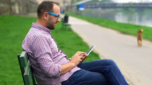 Young Man Using Tablet Computer Standing on Terrace in City 30s