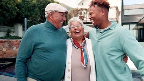 Smiling Senior Couple with Young Man Outside Home