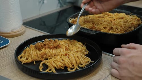Man Cooking Spaghetti with Meat Sauce in Kitchen