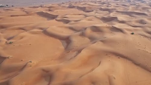Endless Golden Sand Dunes with Majestic Rocky Mountains in the Background
