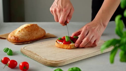 Mains d'homme coupées au couteau Bruschetta au ricotto et tomates grillées sur une planche à découper en bois