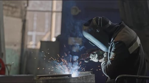 Welder Welds Metal Structures at Factory Stock Clip Masked Welder is Working on Assembly of Metal