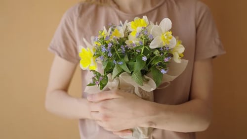 A Woman Holds a Bouquet of Spring Flowers in Her Hands Gently Hugs Them to Her