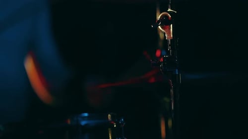Drummer Playing Drums in a Darkened Setting