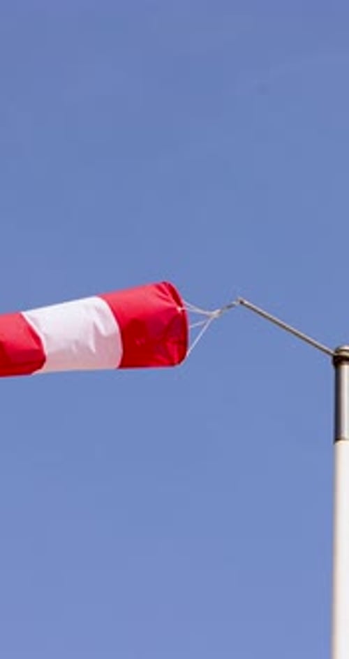 Portrait footage of a wind sock with wind blowing through the sleeve on a clear blue sky sunny day