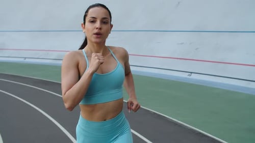 Determined Woman Runs on Track for Fitness
