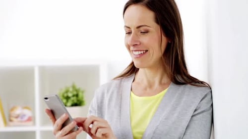 Smiling Woman Using Smartphone in Bright Indoor Setting
