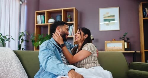 Loving Couple Embracing on Sofa at Home