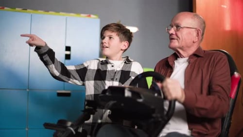 Boy and Senior Man Play Car Racing Video Game