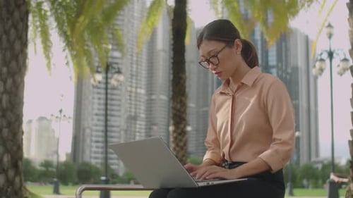 Young Woman Working on Laptop Outdoors