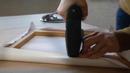 Canvas Being Attached to Wood Frame With Stapler