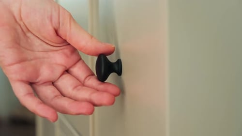 Close-up of a hand opening a drawer. Soft-close drawer. New modern furniture for storing.