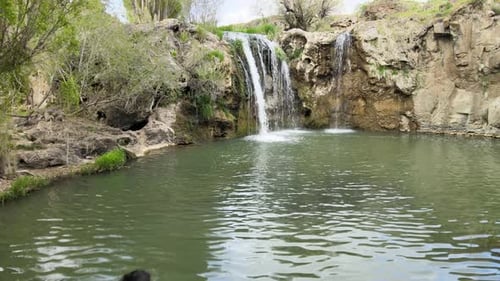 Scenic Waterfall Flowing Into a Serene Pond