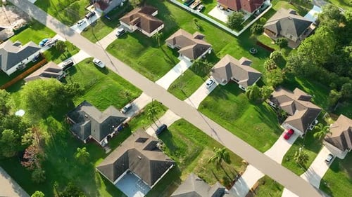 Aerial View of Small Town America Suburban Landscape with Private Homes Between Green Palm Trees in