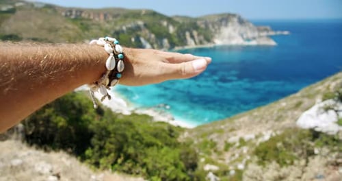 Man Hand Streached in the Air Towards Beautiful Beach
