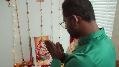 Homme indien priant devant l'autel à Diwali Indoors