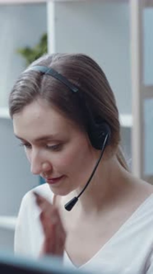 A Professional Woman Engaged in Work at a Call Center Wearing a Headset for Communication