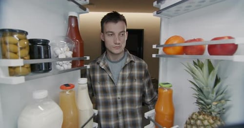 Young Man Grabs Fruit From Refrigerator