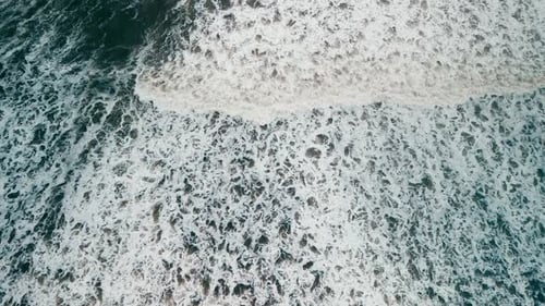 Top View Ocean Waves on a Sandy Beach with White Foam in the Atlantic Ocean