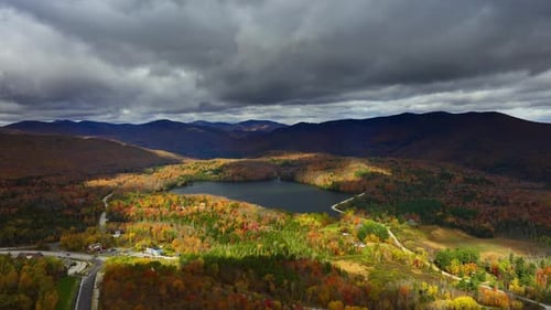 Dramatic cloudscape gathered above the lake surrounded by mountains. Nature of Vermont, New England
