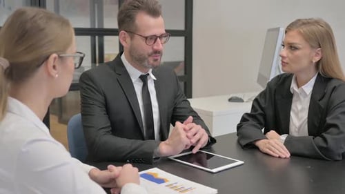 Businessman Talking with Female Employees in Office