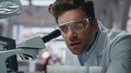 Scientist Working with Microscope in Bright Laboratory