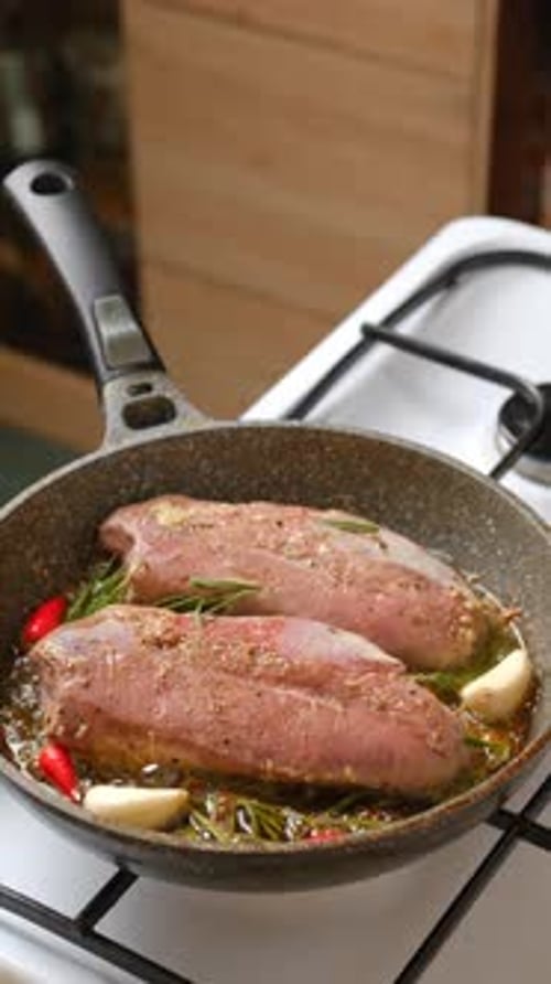 Raw Meat Seasoned with Herbs Cooking in Pan