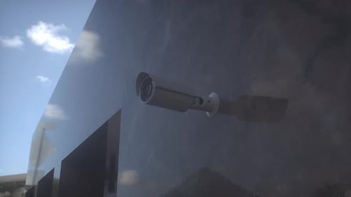 CCTV camera installed on wall of the building. Scan the area for surveillance purposes