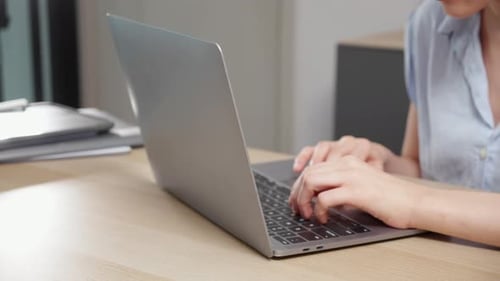 Young caucasian woman sitting and using laptop computer planning for success in modern office.