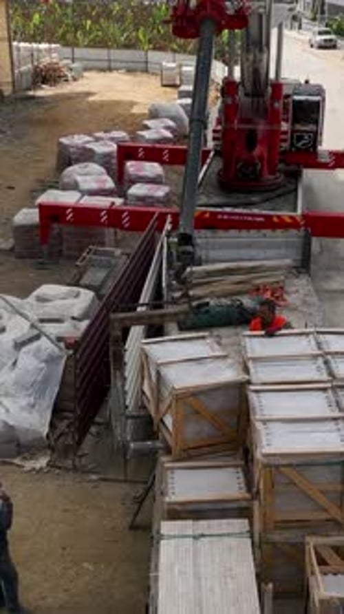 Vertical Video Aerial Construction Scene Crane Unloading Builders in Full Swing
