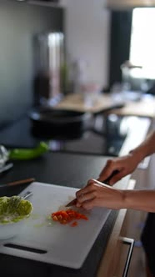 Woman Prepares Vegetables in Bright Kitchen