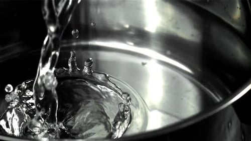 Wasser in einen Topf mit Streuseln gießen, gefilmt mit einer Hochgeschwindigkeitskamera mit 1000 Bildern pro Sekunde