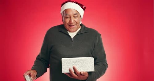 Christmas, gift and pointing with face of old man in studio for announcement