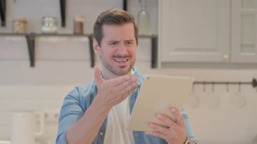 Adult Man Talking on Tablet Device Indoors