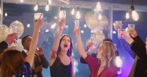 Grupo despreocupado de jovens multirraciais e atraentes passando uma festa corporativa comemorando o feriado ou