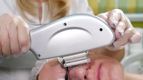 Skin Care Aesthetic Procedure in Modern Cosmetology Clinic Expert Beautician Using Phototherapy