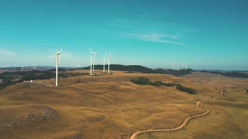 Beautiful aerial view of large field wind turbine generators park on a sunny day
