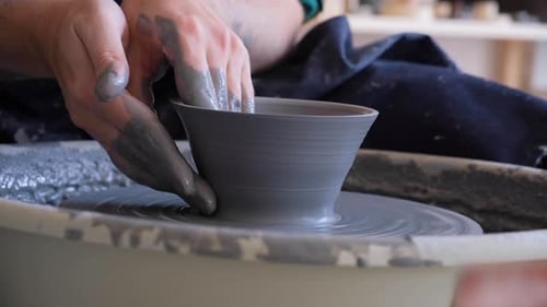 Male Hands Making Ceramic Bowl on Pottery Wheel Man Ceramicist Working with Gray Clay in Workshop