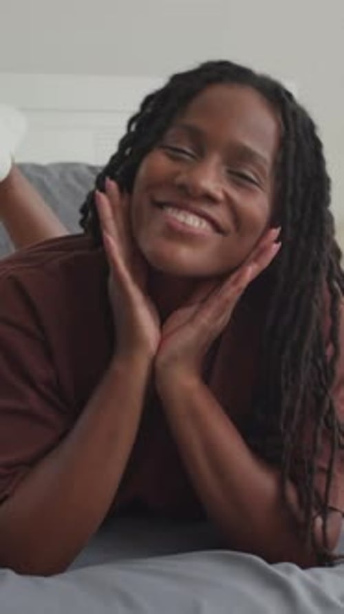 Smiling Woman Relaxing on Bed in Bedroom