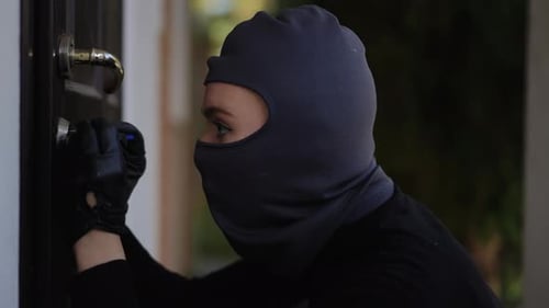 Ein Eindringling versucht in der Abenddämmerung in der Abenddämmerung eine Tür zu entriegeln