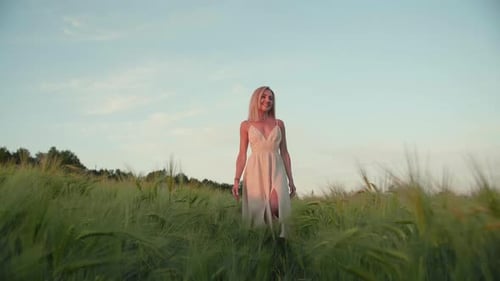 Woman in White Dress Walking Through Field