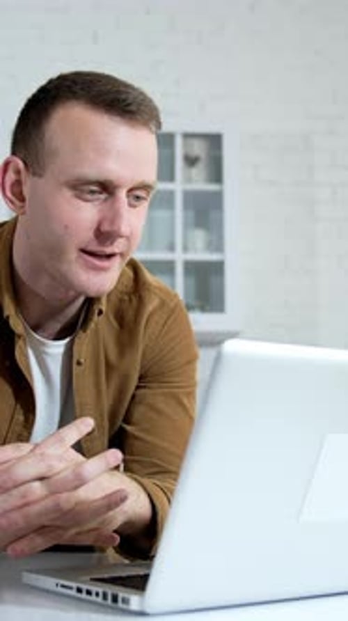 Freelancer working on laptop at home. Young businessman sitting at table at home working on laptop.