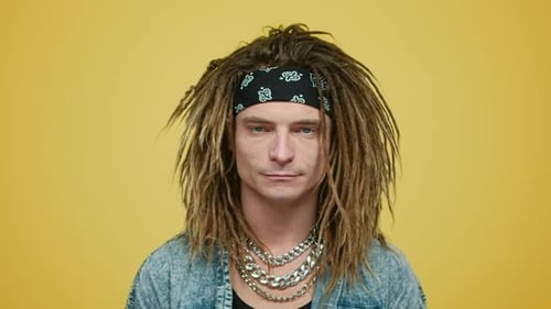 Cara sério com bandana em pé no estúdio. Retrato de homem bonito sorrindo